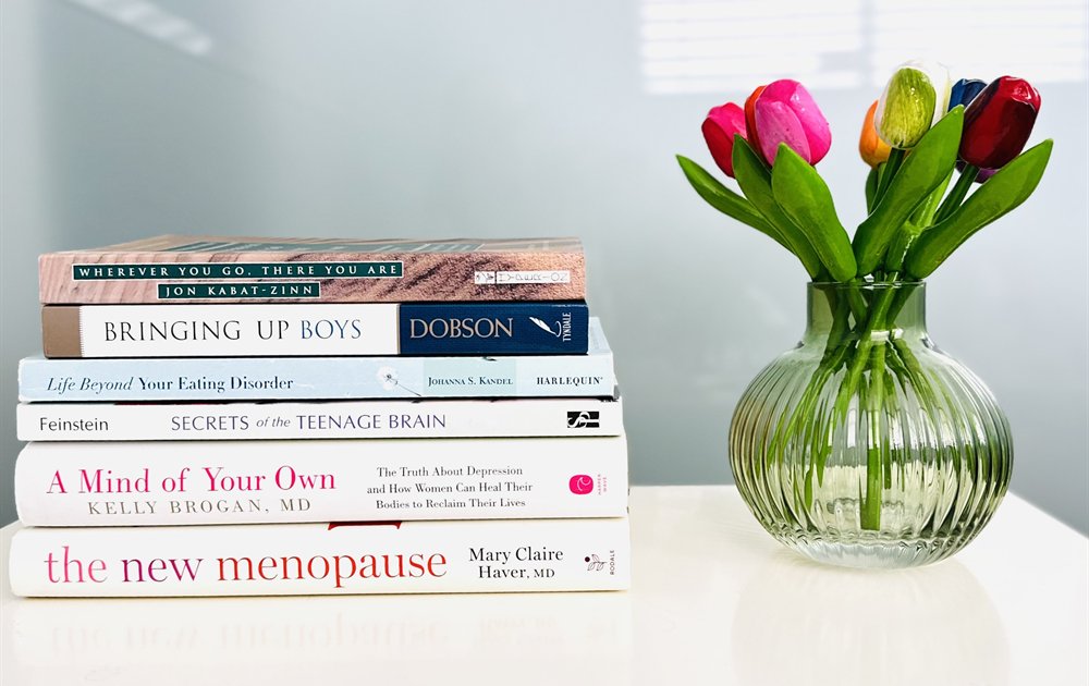 Jennifer's office desk with colorful tulips, books, and a soft lamp